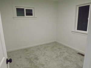 Carpeted empty room with baseboards