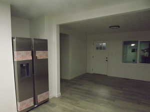Kitchen with stainless steel refrigerator with ice dispenser and wood finished floors
