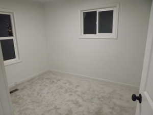 Carpeted empty room with baseboards