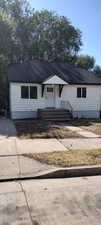 View of front of home featuring a shingled roof and a chimney
