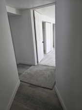 Hall featuring a textured ceiling and wood finished floors