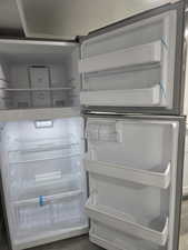 Kitchen view of freestanding refrigerator and dark wood-type flooring