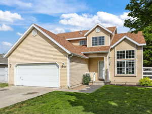 Traditional-style home with concrete driveway, a garage, and a shingled roof