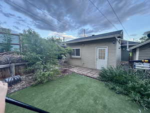 Rear view of house with roof with shingles and an outbuilding