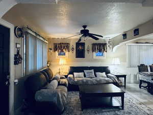 Living area with a textured ceiling and a ceiling fan