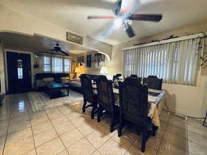 Tiled dining space featuring ceiling fan and a textured ceiling