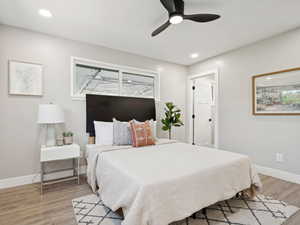 Primary bedroom featuring light wood finished floors, recessed lighting, and a ceiling fan and walk-in closet