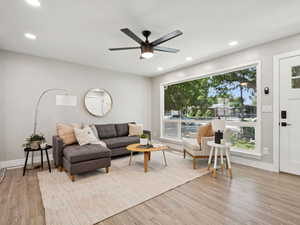 Living room with wood finished floors, healthy amount of natural light, ceiling fan, and recessed lighting