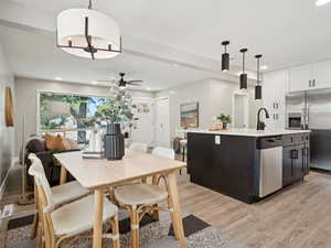 Kitchen with appliances with stainless steel finishes, light wood finished floors, light countertops, a ceiling fan, and recessed lighting