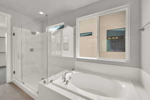 Full bath with a shower stall, a garden tub, and tile patterned flooring