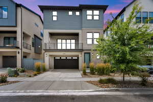 Contemporary house featuring brick siding, an attached garage, and concrete driveway