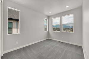 Carpeted empty room featuring baseboards and recessed lighting