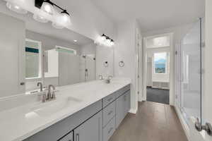Bathroom featuring a stall shower, double vanity, tile patterned floors, and recessed lighting