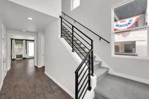 Stairs featuring hardwood / wood-style floors, healthy amount of natural light, and recessed lighting