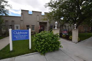 Community / neighborhood sign featuring a lawn