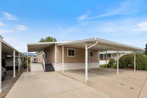 View of front of house featuring an attached carport and concrete driveway