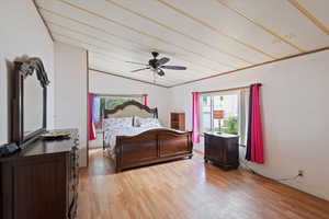 Bedroom featuring vaulted ceiling, light wood finished floors, and a ceiling fan