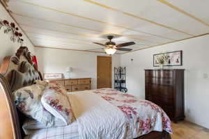 Bedroom with a ceiling fan and light tile patterned floors