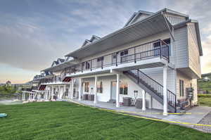 Back of house with stairway and a yard