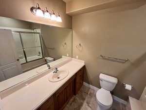 Bathroom featuring vanity and bath / shower combo with glass door