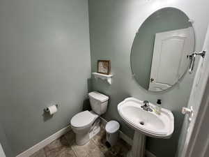 Half bath featuring toilet and baseboards