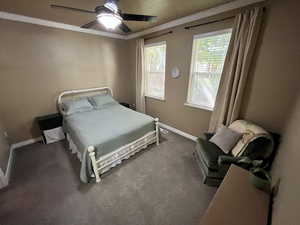 Bedroom featuring carpet flooring, ornamental molding, and ceiling fan