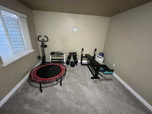 Exercise area featuring baseboards and carpet floors