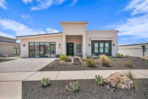 Contemporary home featuring concrete driveway, stucco siding, and an attached garage
