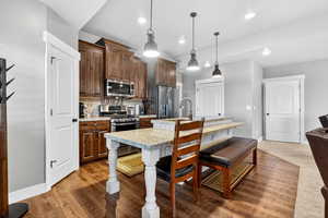 Second Kitchen with appliances with stainless steel finishes, an island with sink, a kitchen bar, decorative backsplash, and recessed lighting