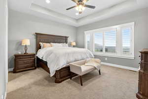 Bedroom featuring a raised ceiling, carpet flooring, a ceiling fan, and recessed lighting