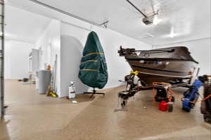 Garage featuring a garage door opener and baseboards