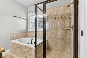 Bathroom featuring a garden tub and a shower stall