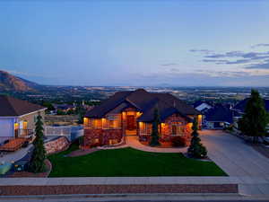 Craftsman-style home featuring driveway and stone siding