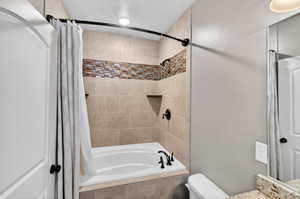 Bathroom featuring tiled shower / bath, vanity, and recessed lighting