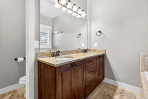 Bathroom featuring double vanity and baseboards