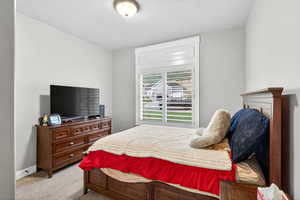 Bedroom with light carpet and a textured ceiling