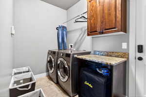 Laundry room featuring cabinet space, independent washer and dryer, and a textured ceiling