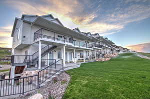 View of side of property featuring stairs and a lawn