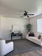 Living room with wood finished floors, a ceiling fan, and a textured ceiling
