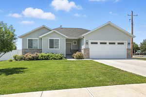 View of front facade featuring an attached garage, driveway, and brick siding