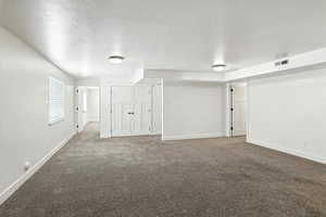 Unfurnished room featuring carpet and a textured ceiling