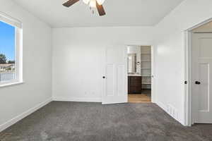 Unfurnished bedroom with carpet flooring, multiple windows, and a ceiling fan