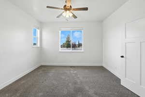 Spare room featuring carpet flooring and ceiling fan