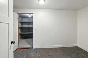 Unfurnished room featuring baseboards and carpet