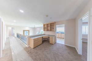 Home office featuring built in study area, light carpet, and recessed lighting