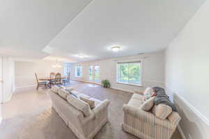 Living room featuring carpet and a chandelier