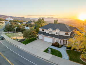 View of front of property featuring concrete driveway, an attached garage, a mountain view, and stucco siding