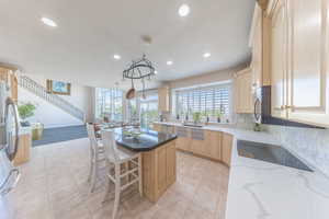 Kitchen with light brown cabinets, recessed lighting, a kitchen island, healthy amount of natural light, and appliances with stainless steel finishes