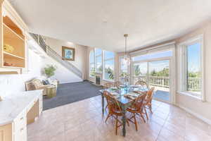 Dining space with light tile patterned flooring, a textured ceiling, and light carpet