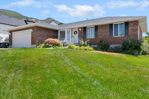 Single story home featuring a garage, brick siding, a front lawn, and roof with shingles
